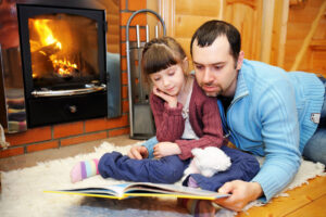 Father and daughter reading in front of the fireplace