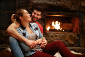 Young couple sitting in front of the fireplace enjoying a date night at home